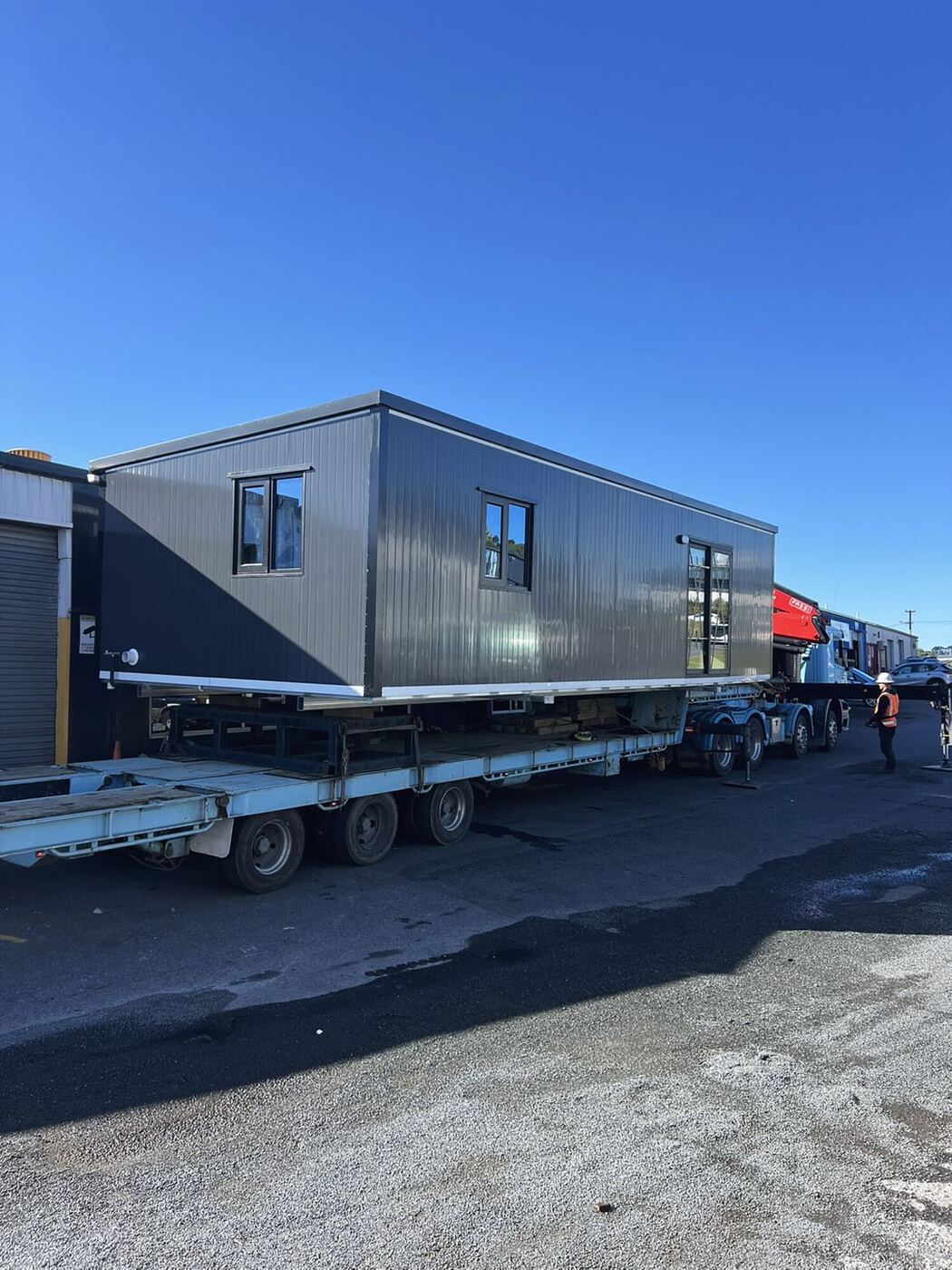 A 10 × 4 m Simple Cabins cabin loaded on a trailer in the yard