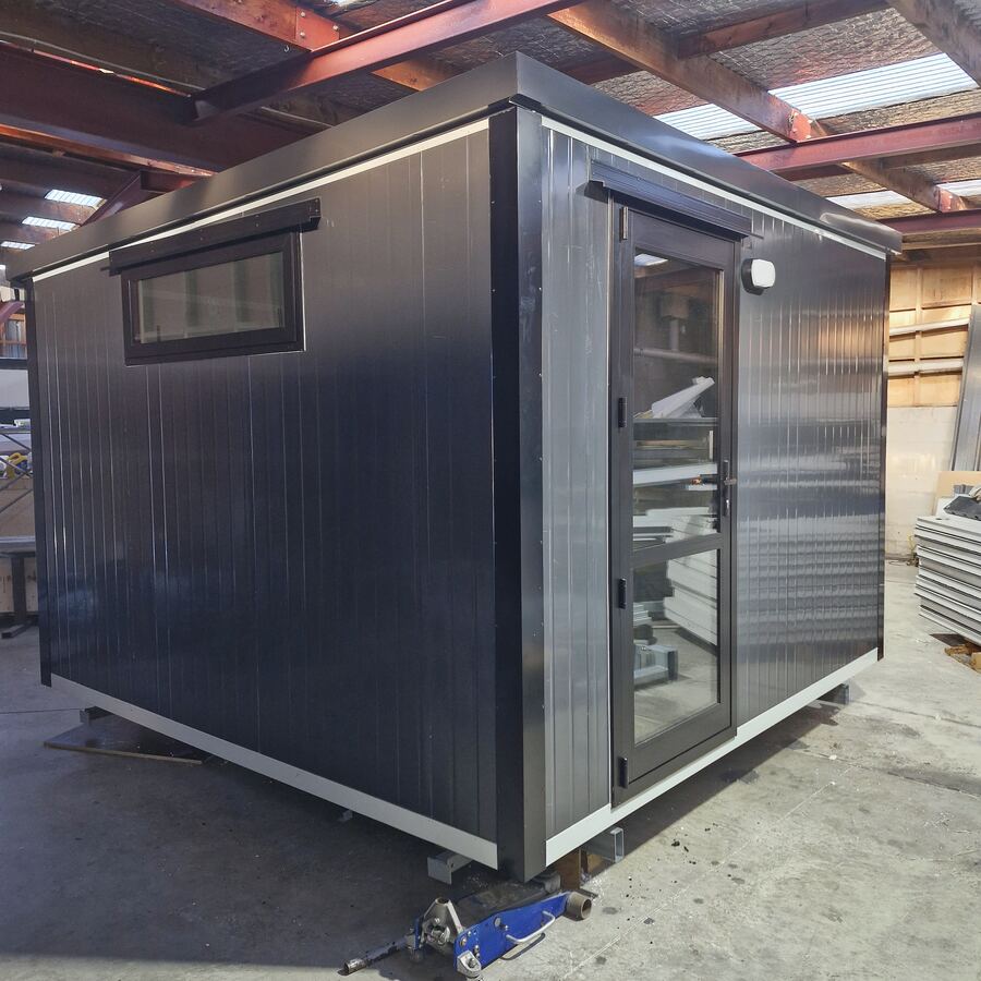 A small charcoal cabin with a glazed door, finished in the workshop