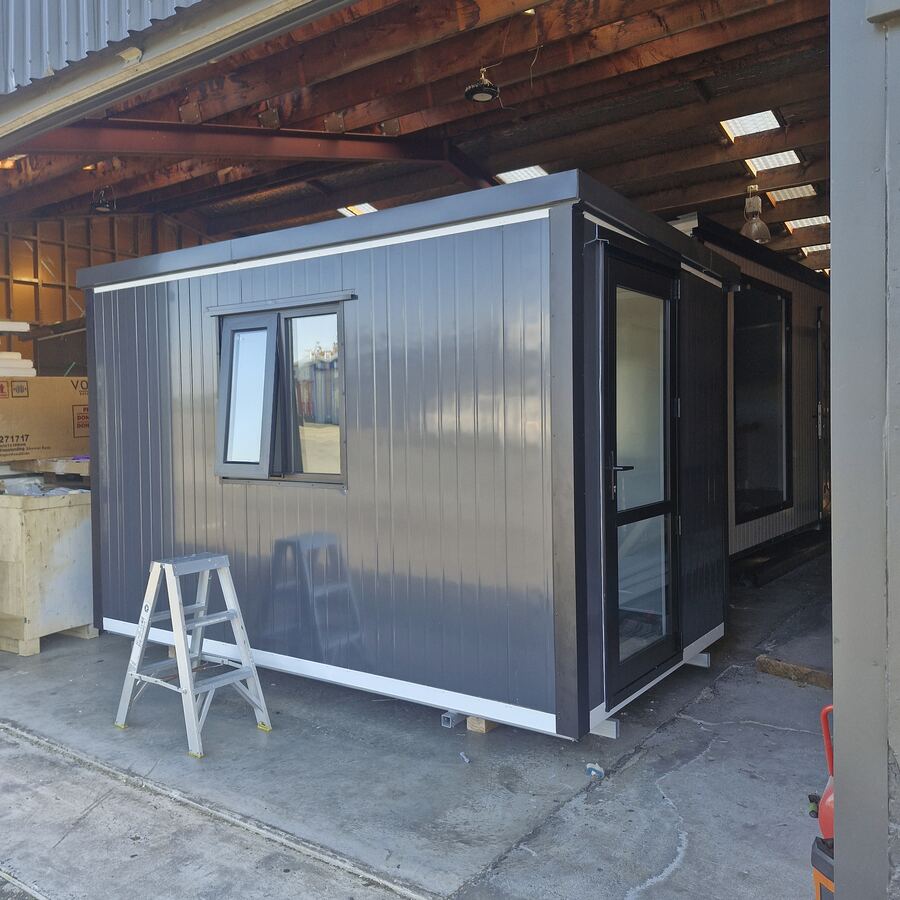 A charcoal cabin with an awning window and glazed door in the workshop